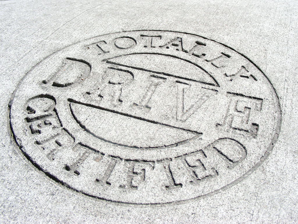 Commercial Drive Seal designed by Far & Wide stamped into concrete sidewalks